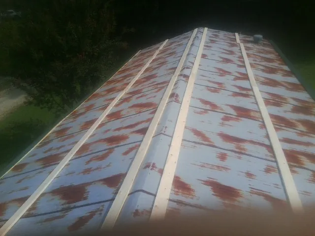 Rusted metal roof panels with new wood purlins before replacement — Storm Damage Roof Repair in Melcroft by Roofing Brothers