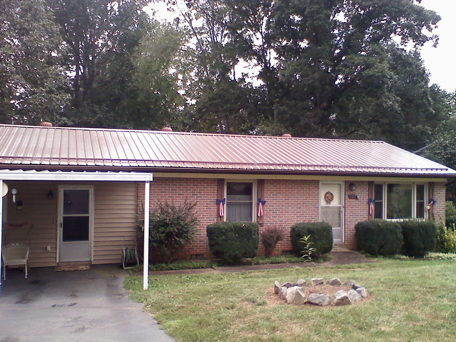 Bronze metal roof and carport on a brick ranch home — Roof Repair work by our crew in Melcroft