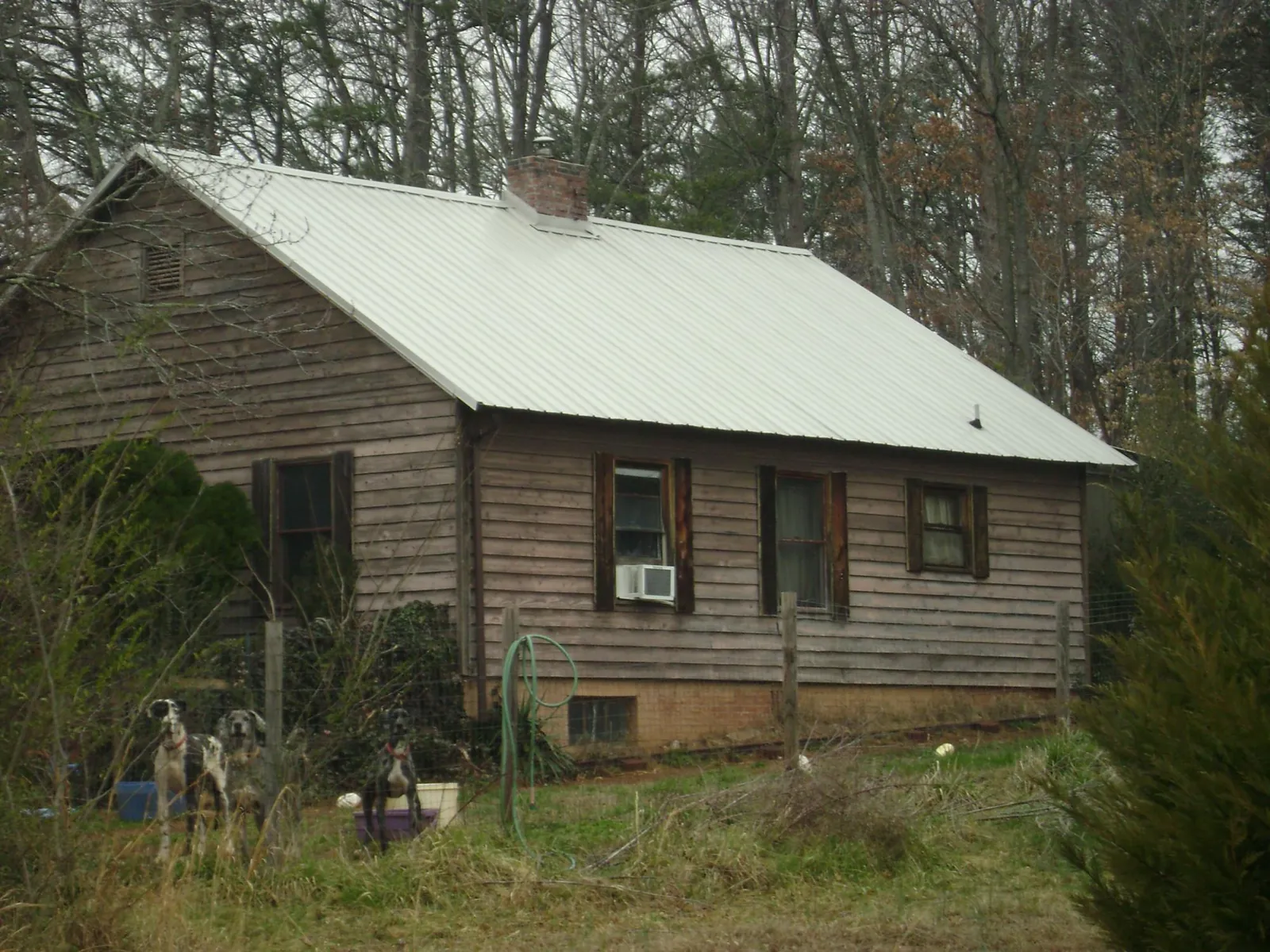 White metal roof on an old wood sided farmhouse, from a Metal Roof Installation job in Melcroft